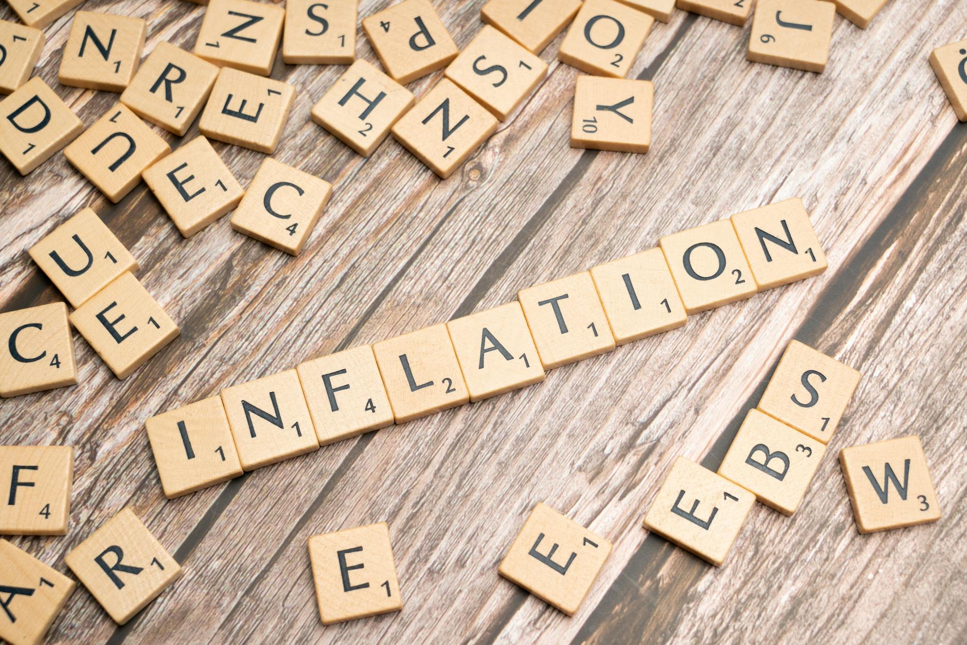 Scrabble tiles spelling 'Inflation' on a wooden surface