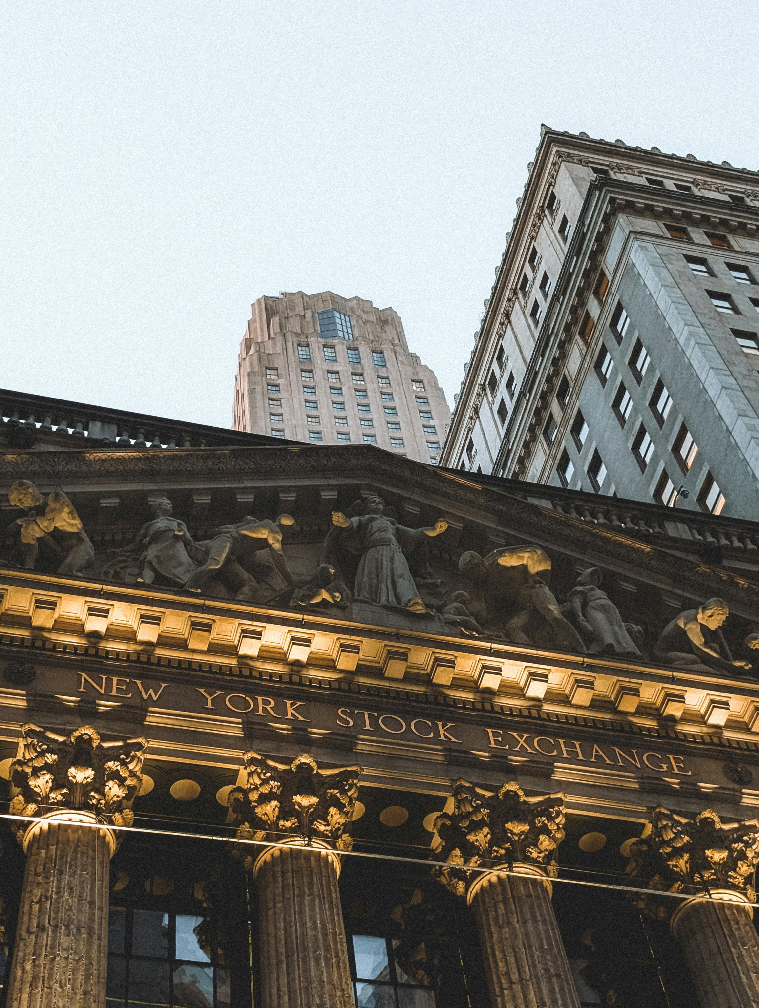 New York Stock Exchange facade at dusk with skyscrapers in background