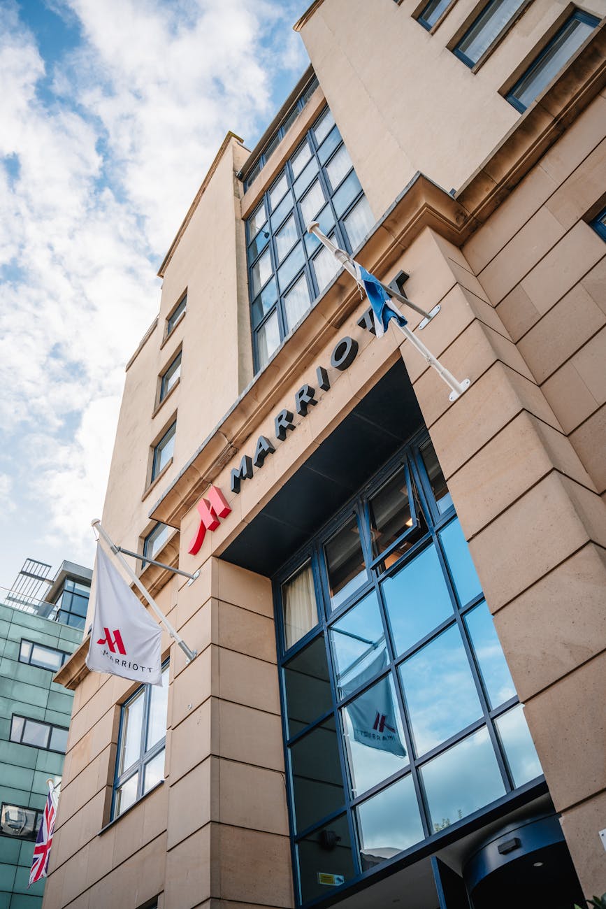 Modern Marriott hotel facade with branded flag against a clear blue sky