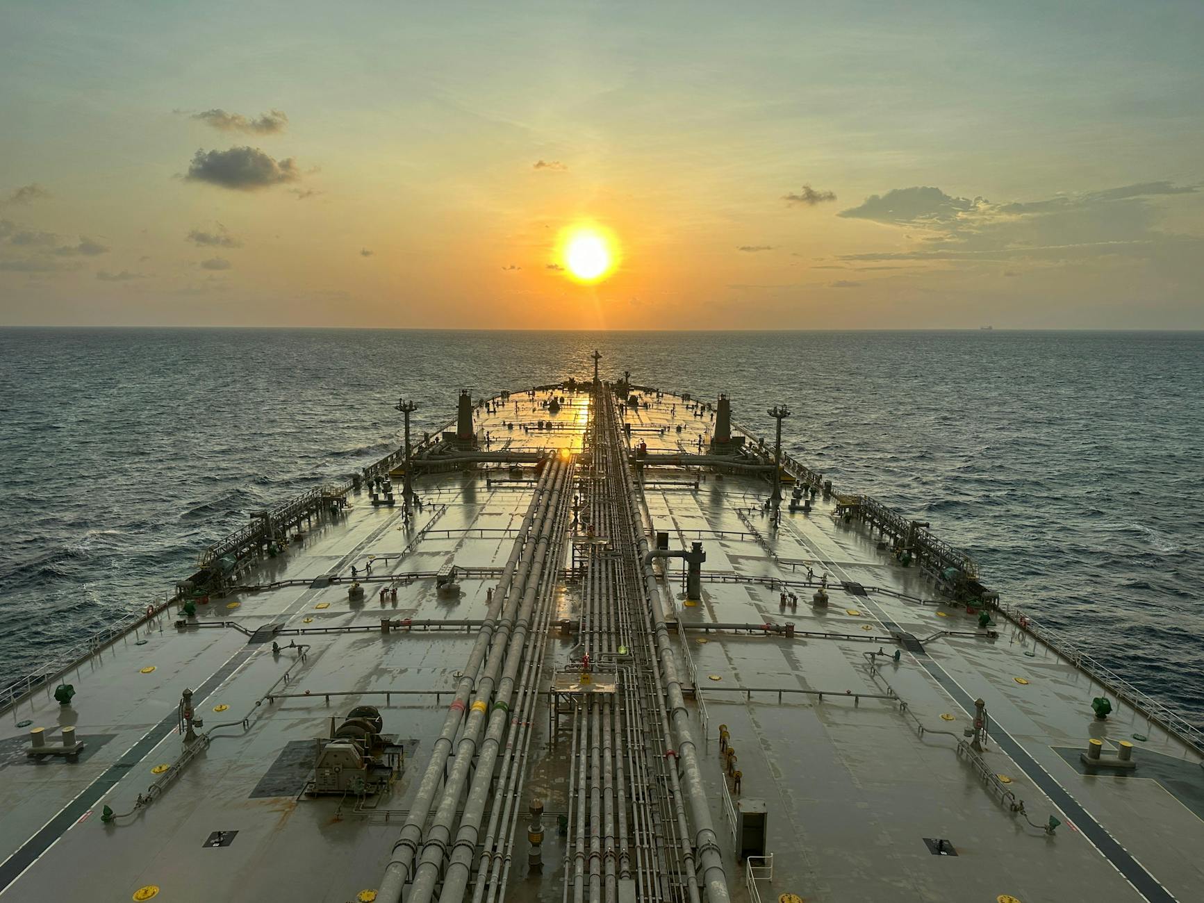 Large oil tanker sailing across the open ocean at sunset