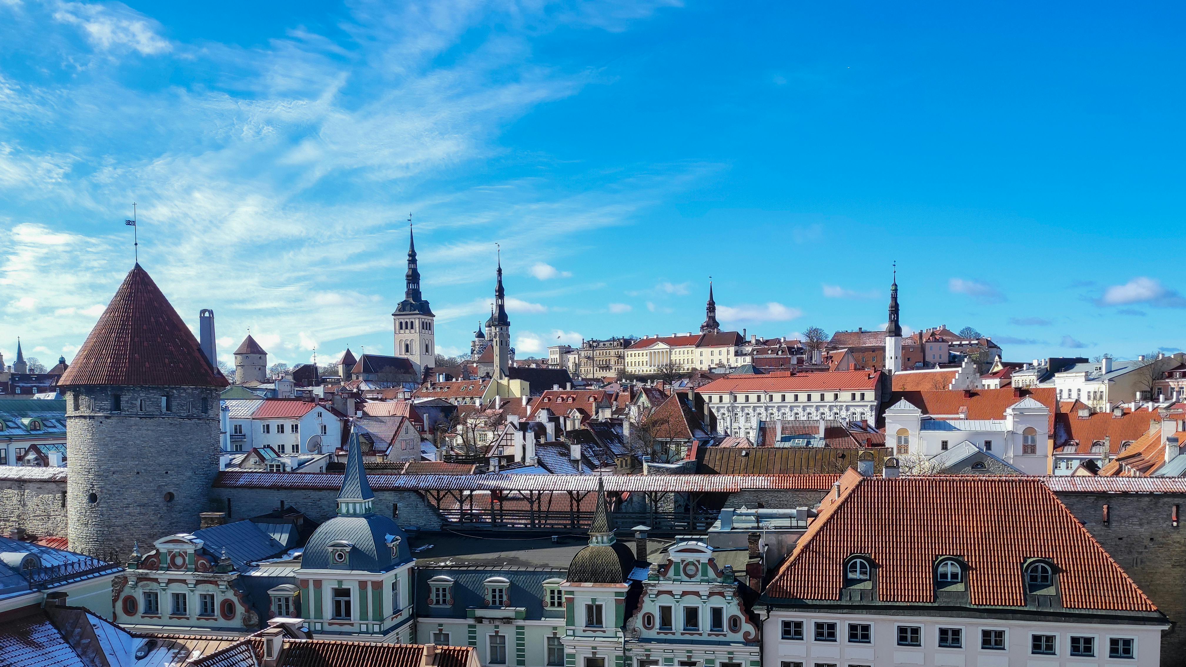 Historic skyline of Tallinn Old Town with church spires and rooftops under a blue sky