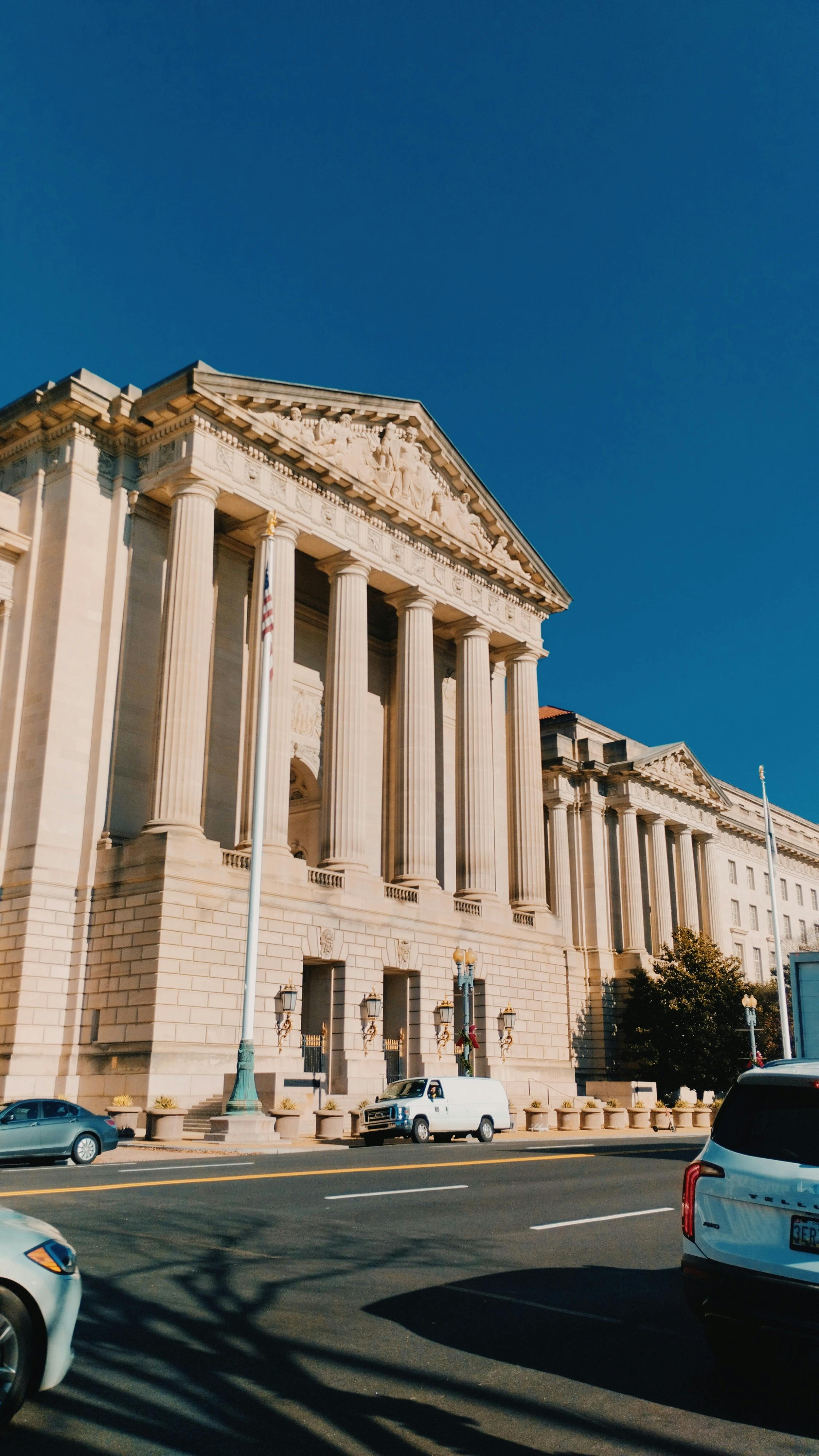 Neoclassical government building facade in Washington, D.C. under a clear sky