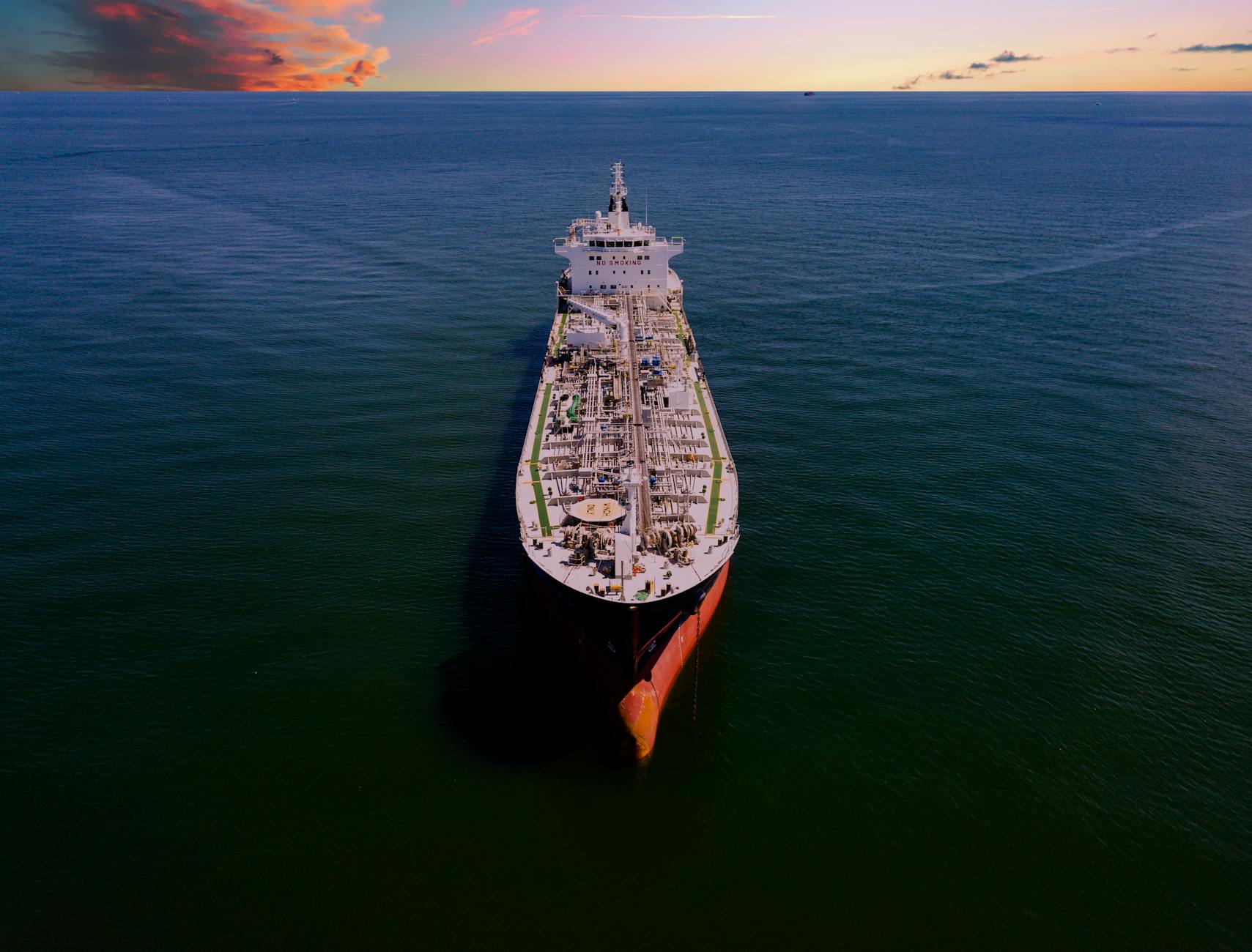 Aerial drone photograph of an oil tanker at sea during sunset