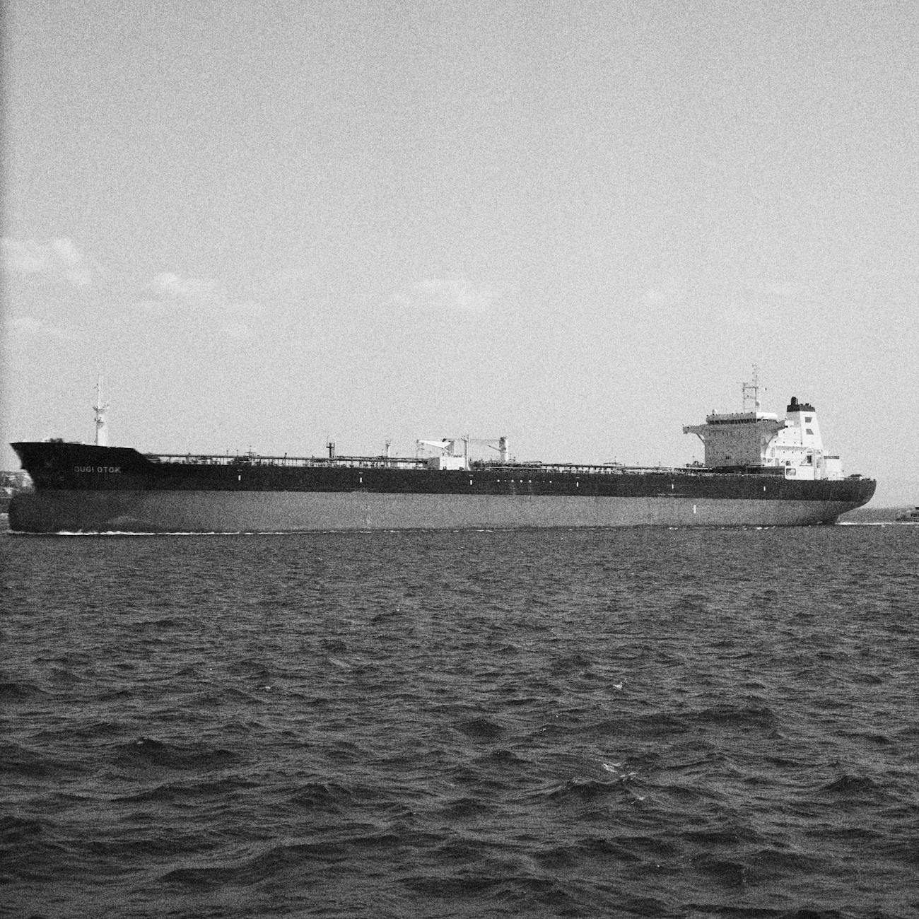 Oil tanker navigating open sea under clear sky