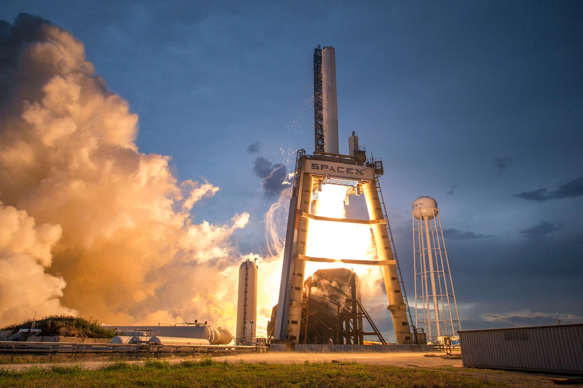 SpaceX rocket launch against a colorful dusk sky