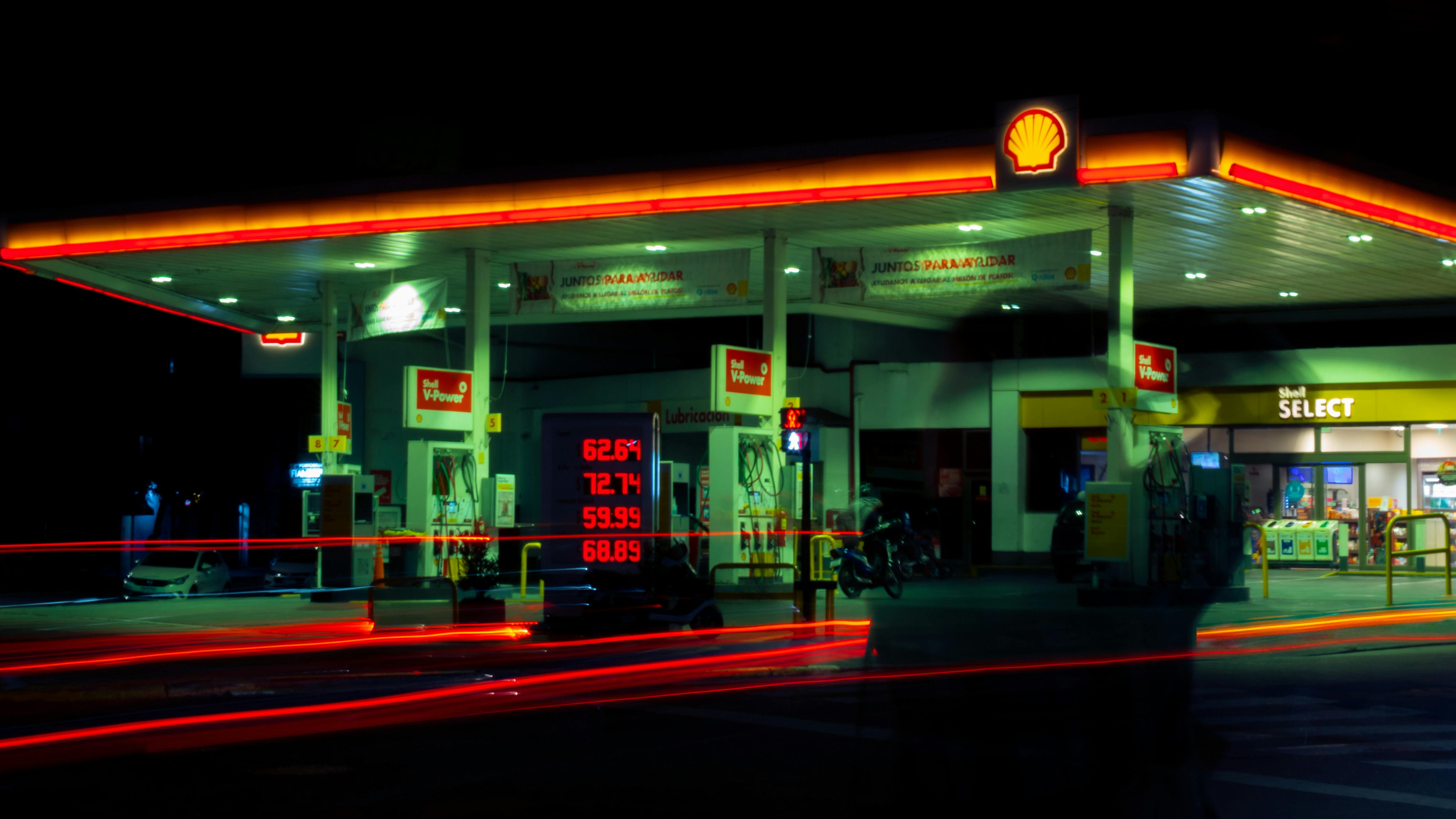 Illuminated Shell gas station with long exposure light trails at night