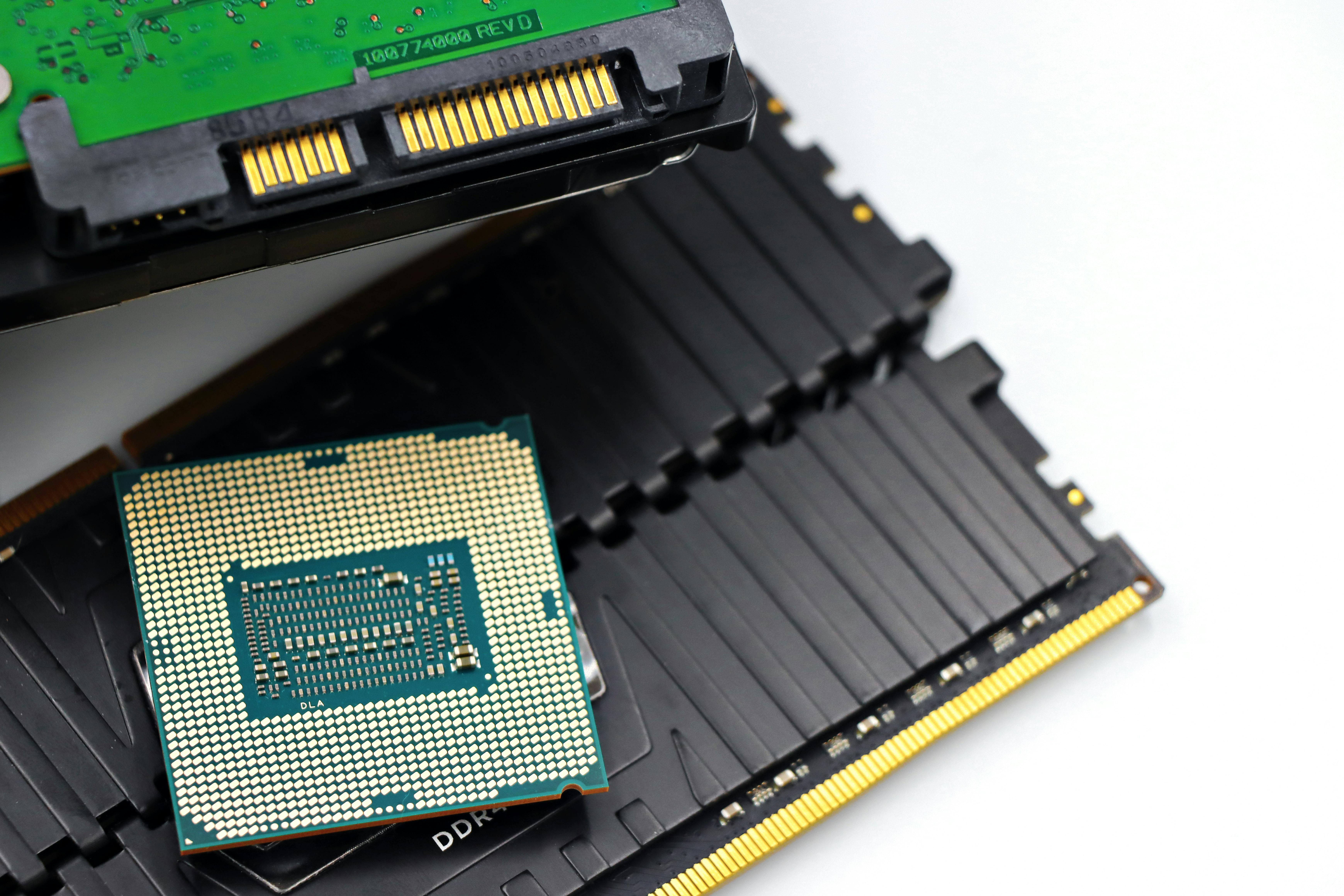 Close-up of a CPU and RAM modules on a white surface, illustrating computer memory hardware components