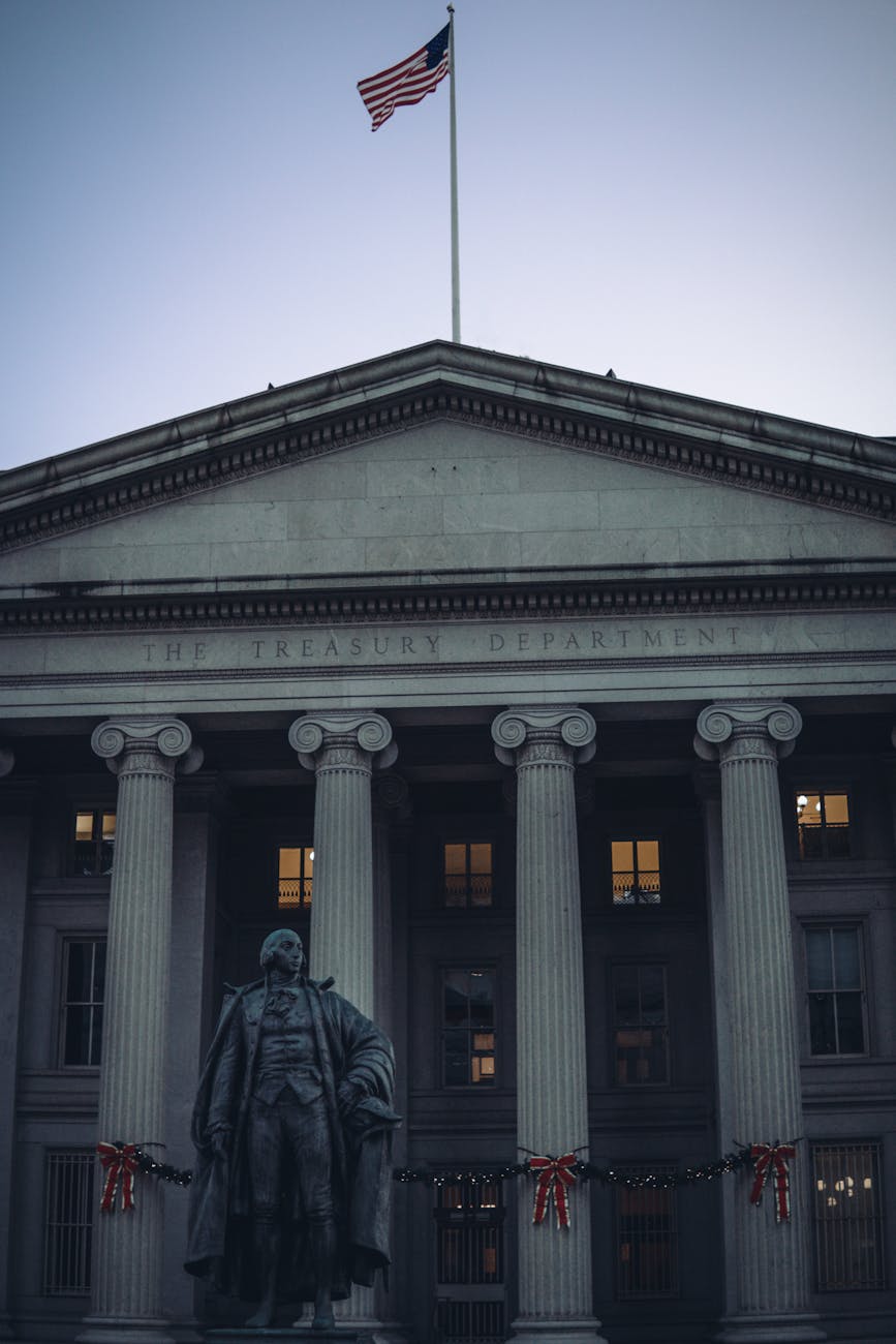 US Treasury Department building facade with columns and American flag at dusk in Washington, DC