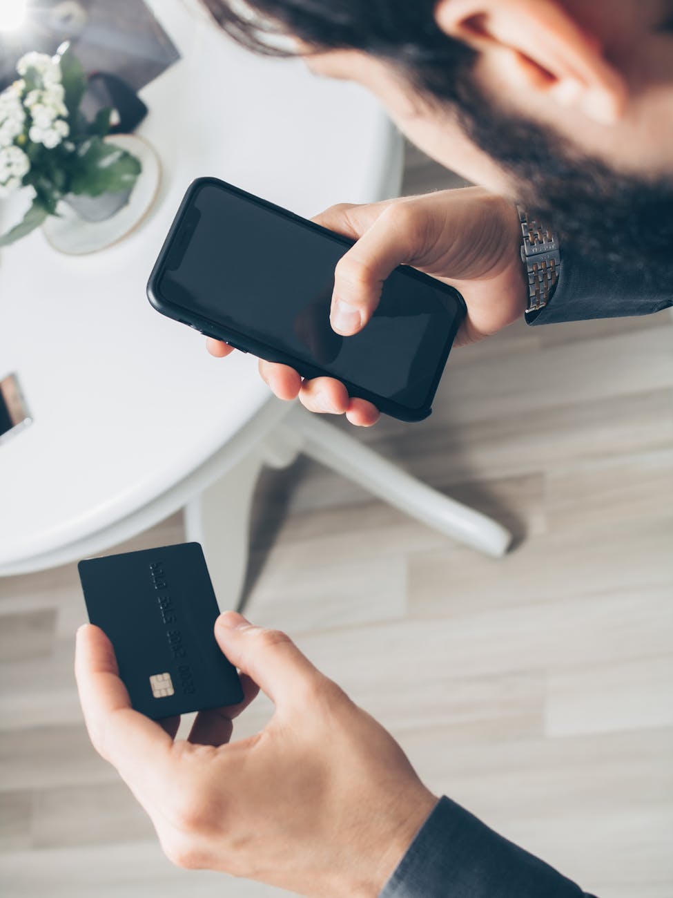 Person holding a smartphone and credit card for an online payment, representing digital finance and fintech
