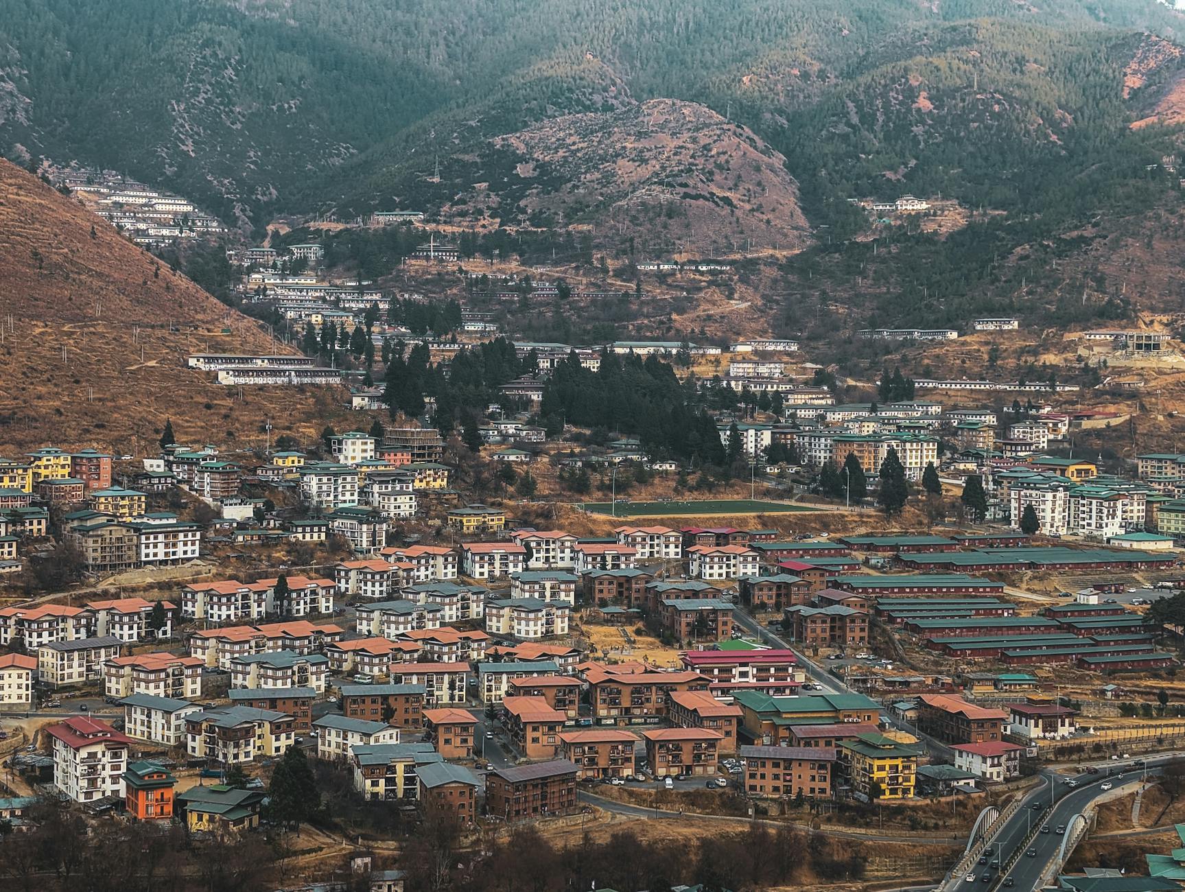 Aerial view of Thimphu city, Bhutan's capital, amid mountain landscapes.