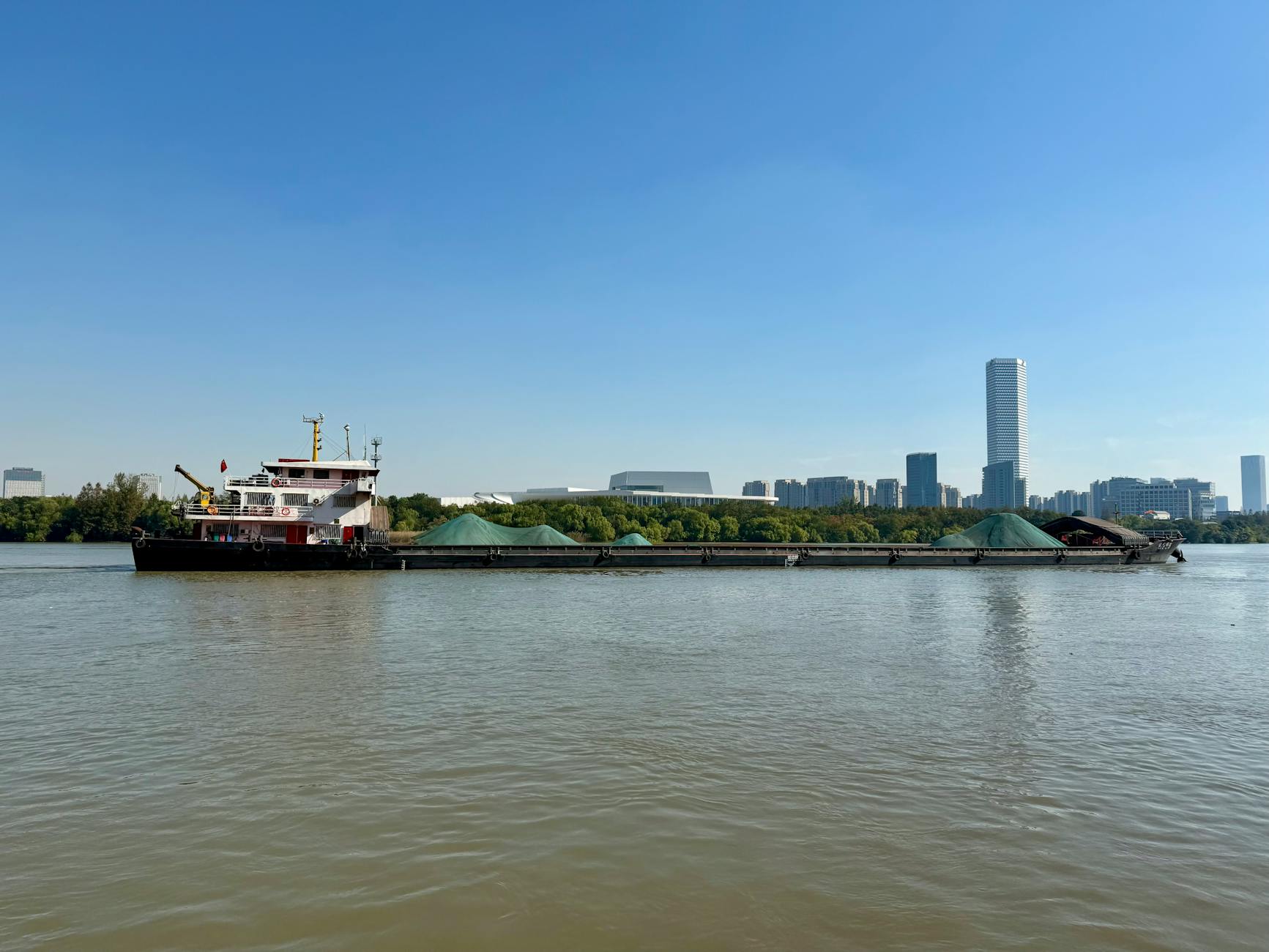 Cargo ship on the Huangpu River with the Shanghai skyline in the background