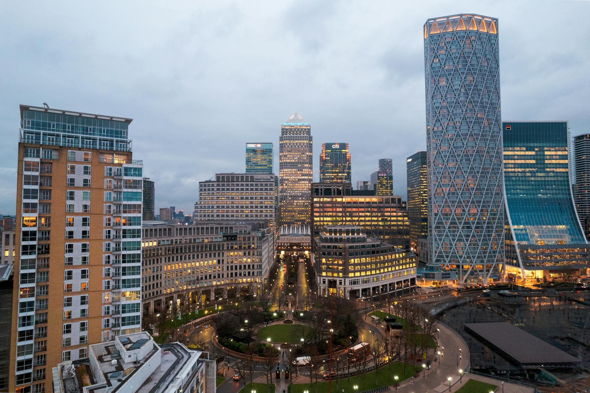Panoramic aerial view of Canary Wharf, London's financial district, at dusk showcasing tall skyscrapers and modern architecture.