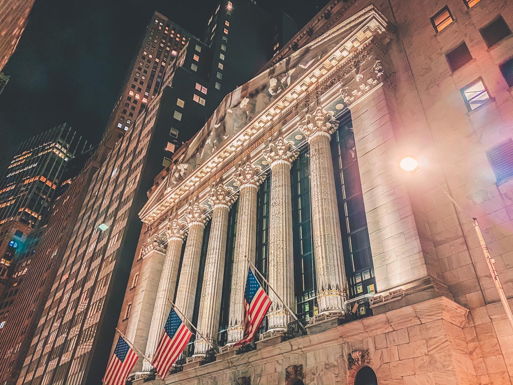 New York Stock Exchange facade illuminated at night in Manhattan