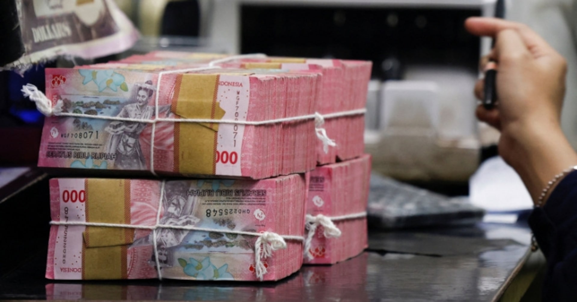 A teller prepares rupiah bank notes at a money changer in Jakarta