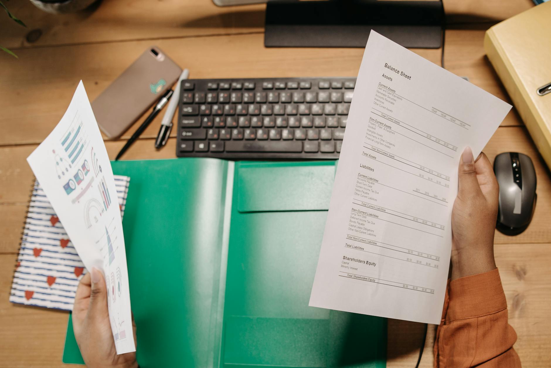 Business meeting documents and laptop representing financial reporting and AI investment analysis