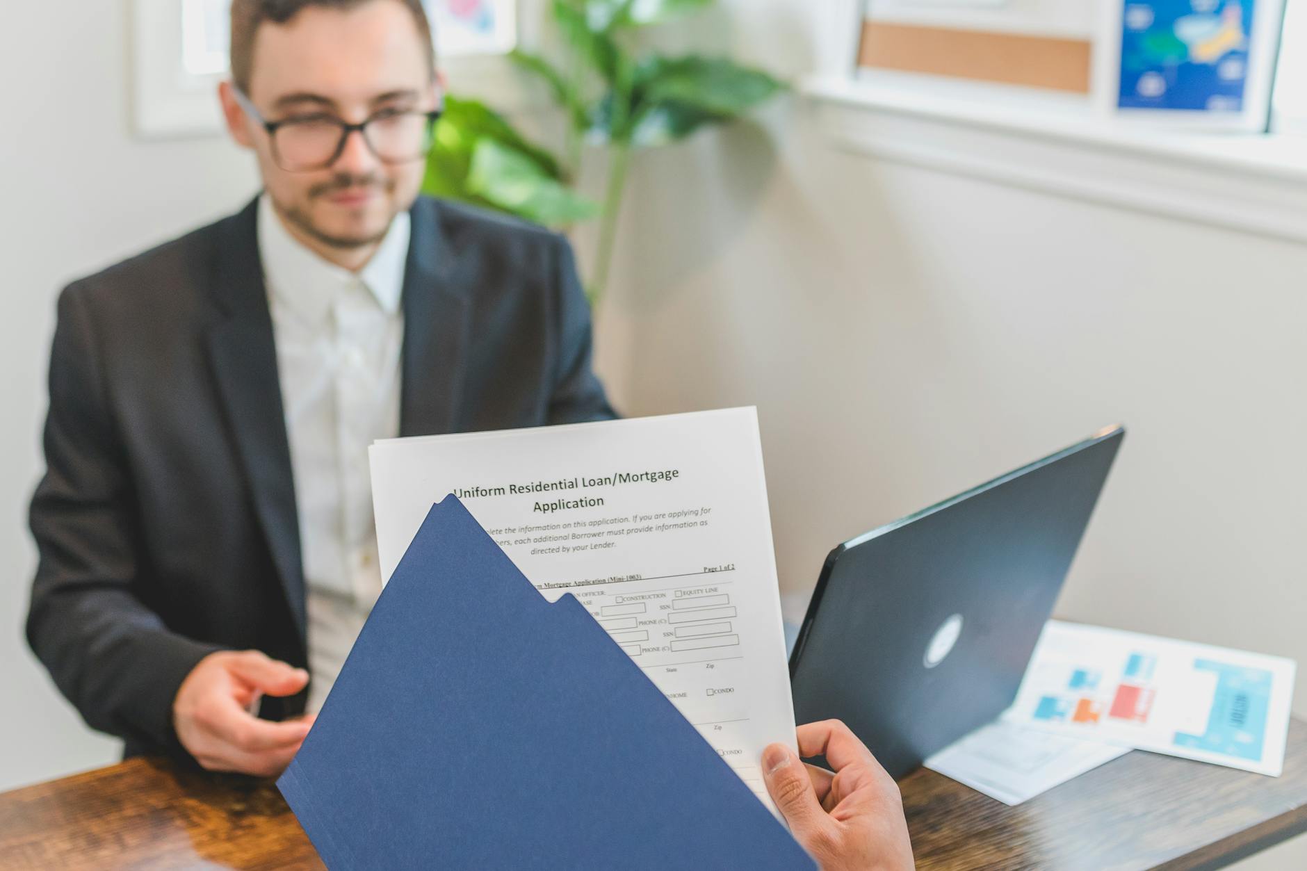 Borrower reviewing loan documents across a desk while planning a repayment change.