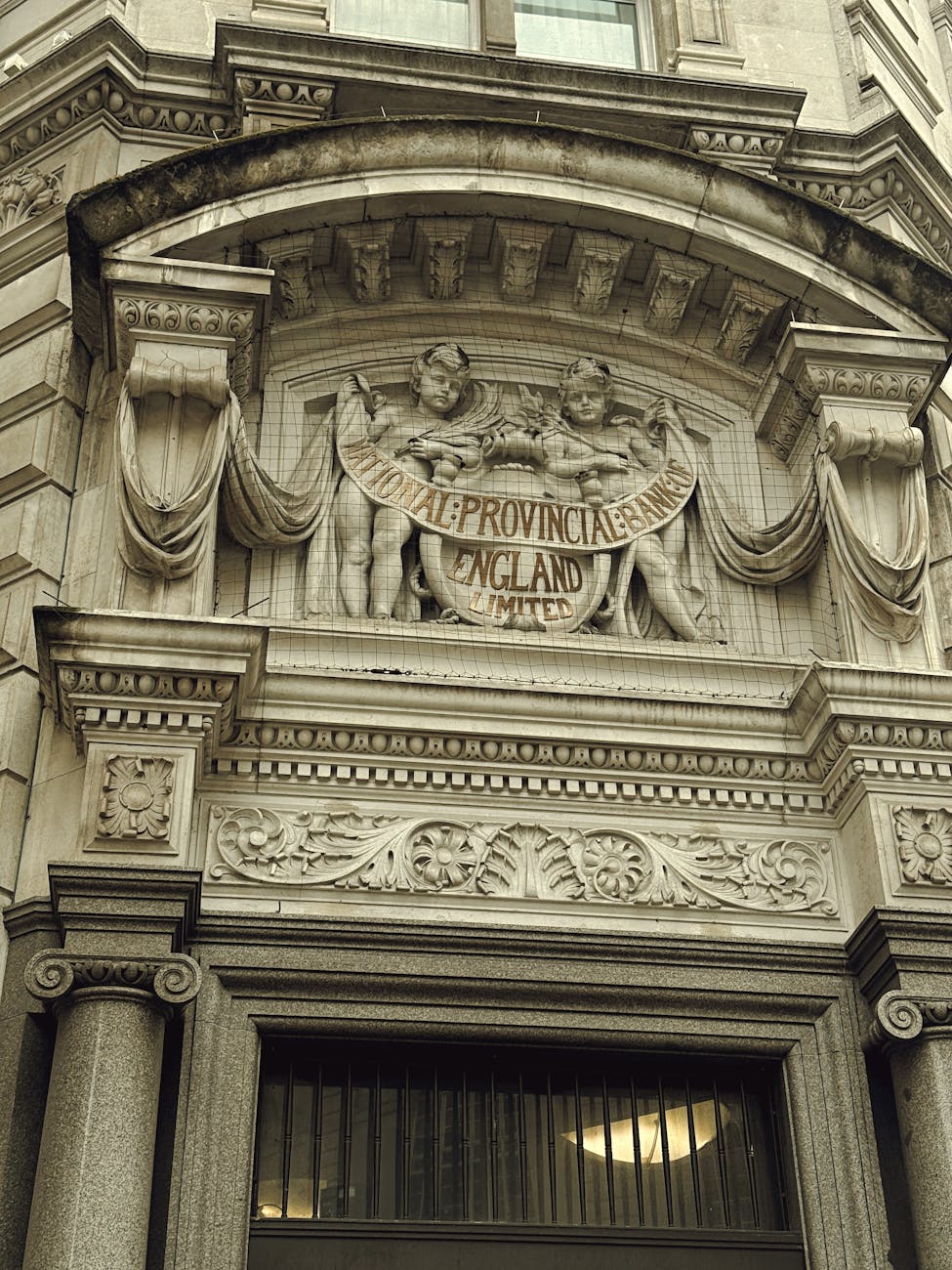 Stone facade of a traditional bank building in England, illustrating a UK savings institution story.