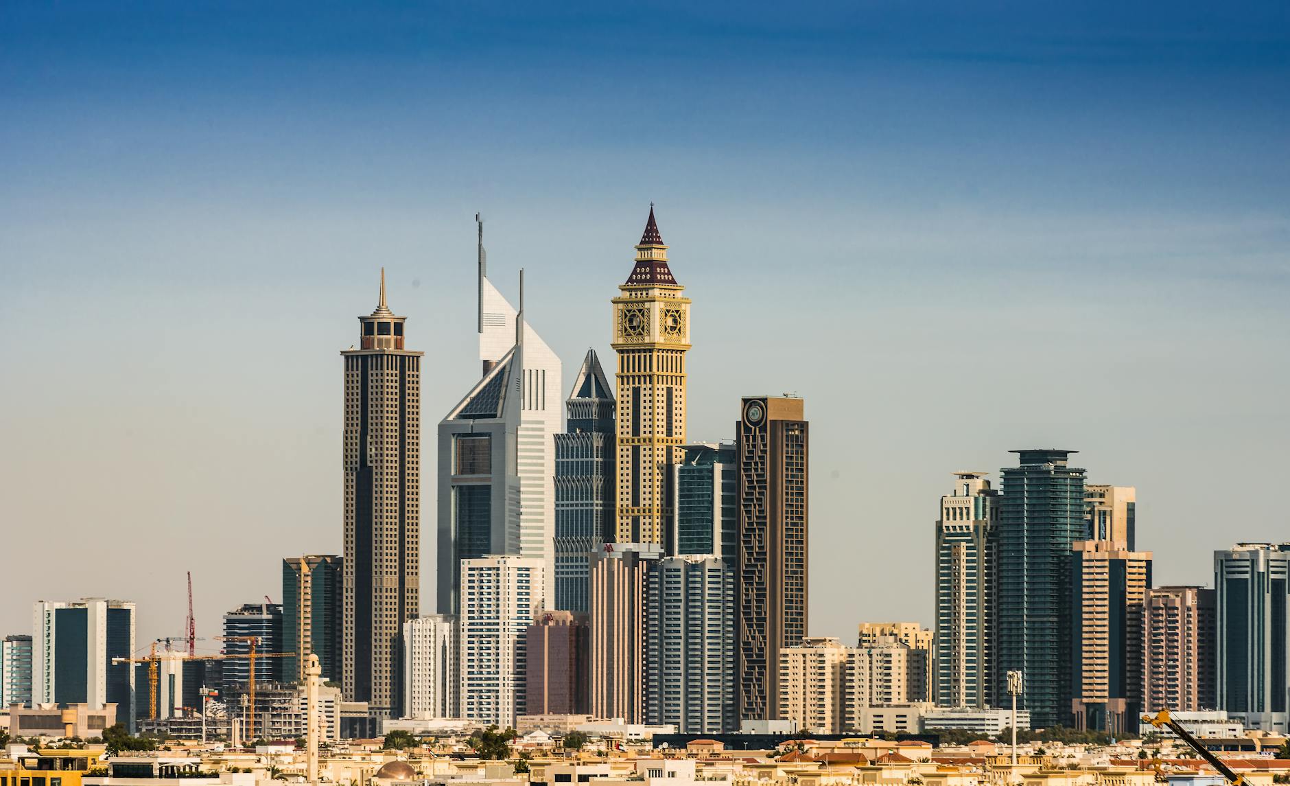 Panoramic view of Dubai's modern skyline and financial district under a clear sky.