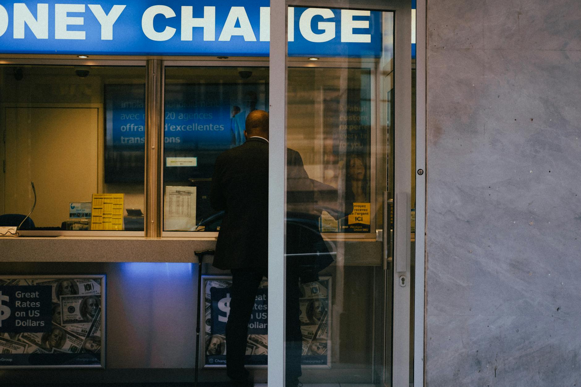 Currency exchange window displaying multi-currency rates in a city office.
