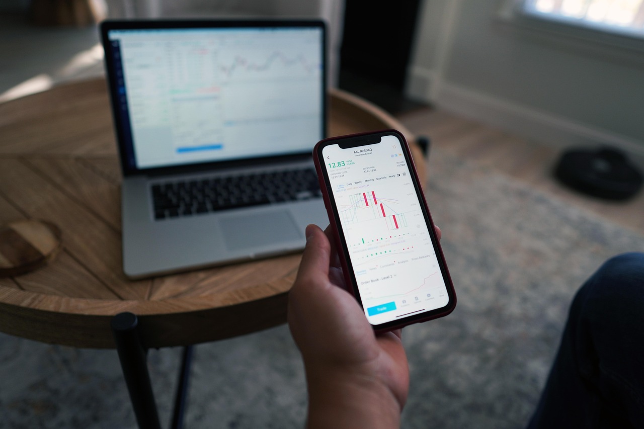 Hand holding a smartphone with stock market data on screen