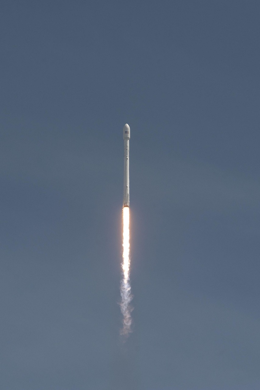 SpaceX Falcon 9 rocket launching at night with bright propulsion flames