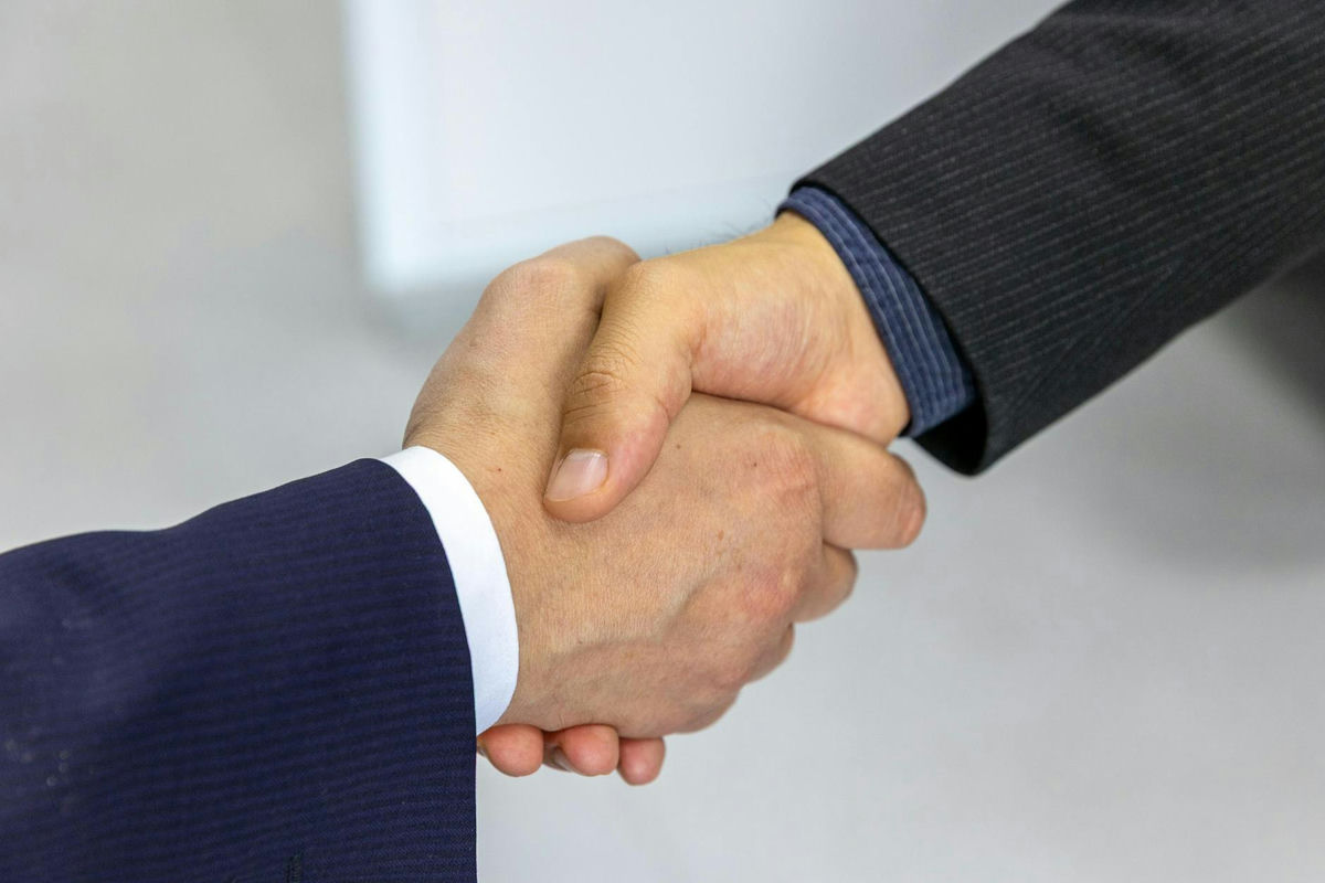 A handshake representing cross-border dealmaking between companies