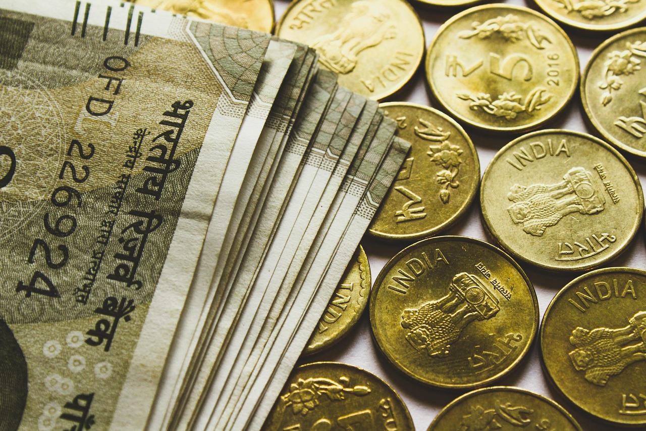 Indian rupee banknotes and coins, representing pressure on India’s currency and external account.