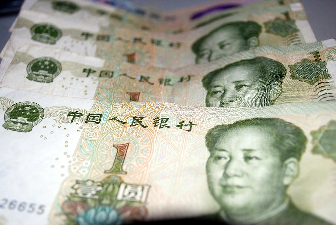 Yuan banknotes arranged as China tightens rules on outbound investment.
