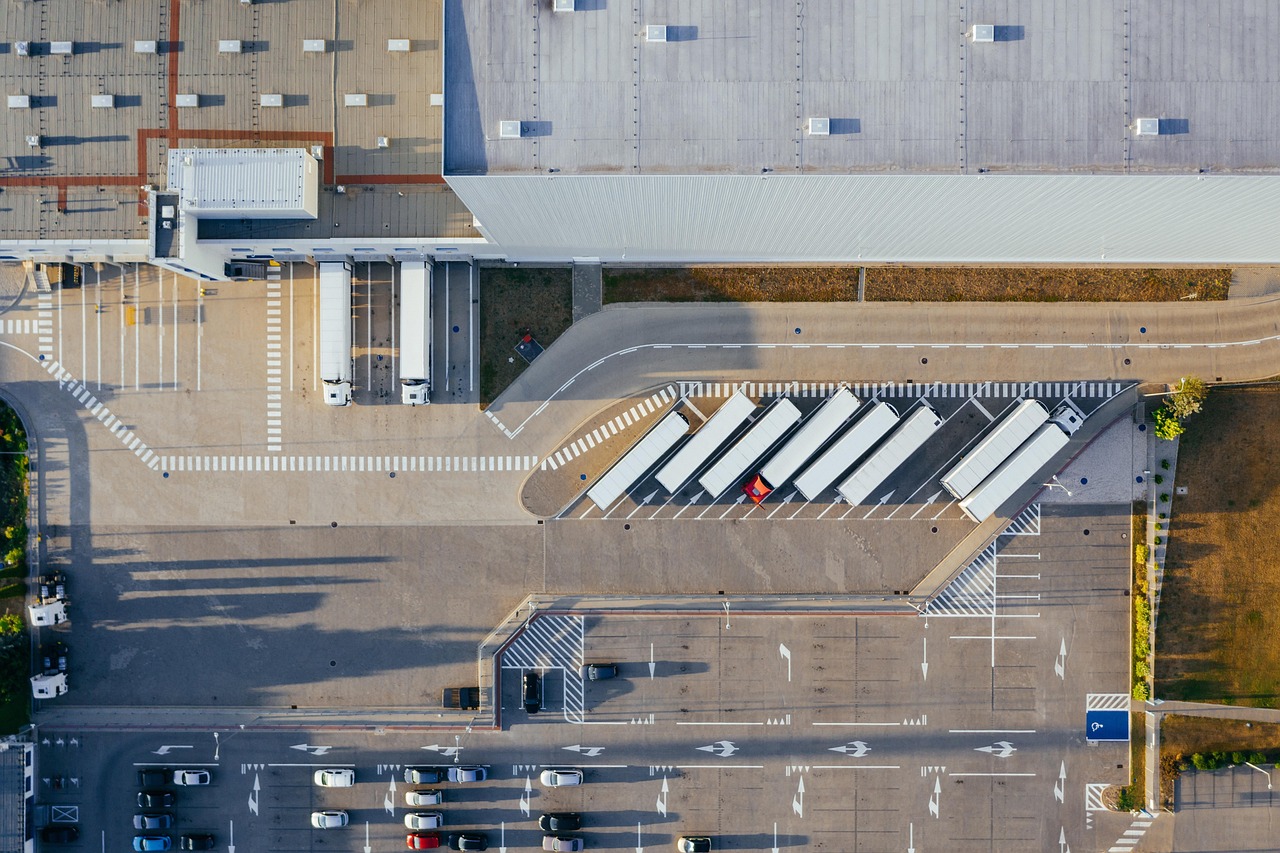 Aerial view of trucks and loading bays at a logistics distribution center.