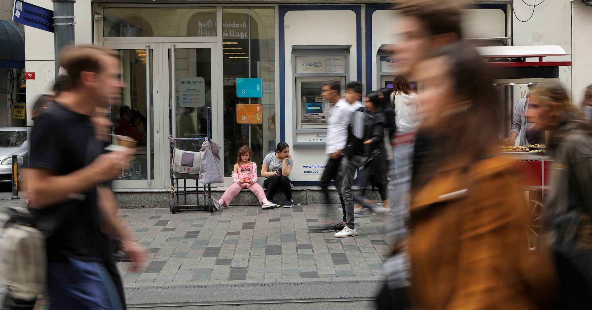 People walk past a Halkbank branch in central Istanbul, Turkey