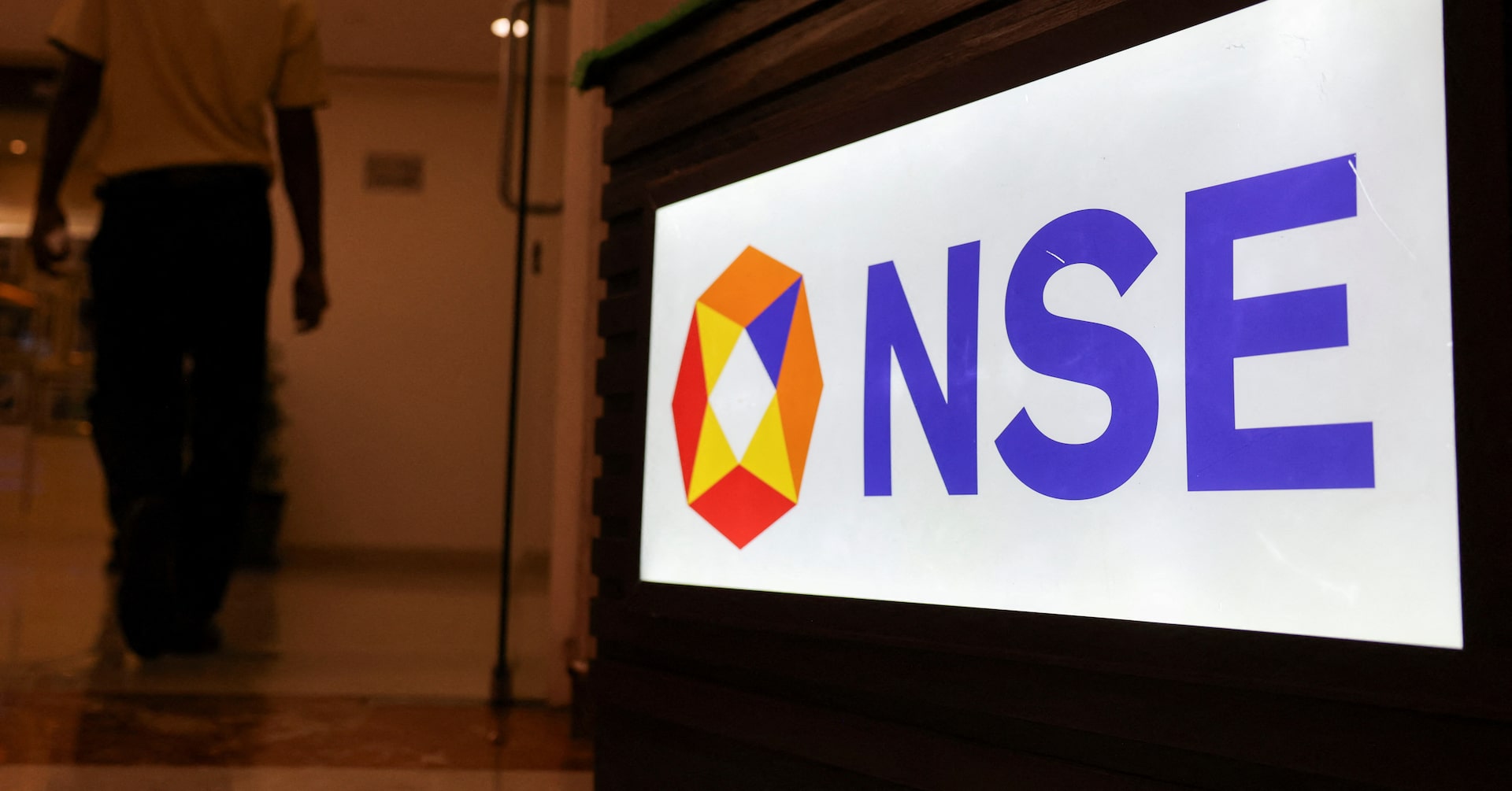 A man walks past the logo of the National Stock Exchange (NSE) in Mumbai, India, August 9, 2024. REUTERS/Francis Mascarenhas