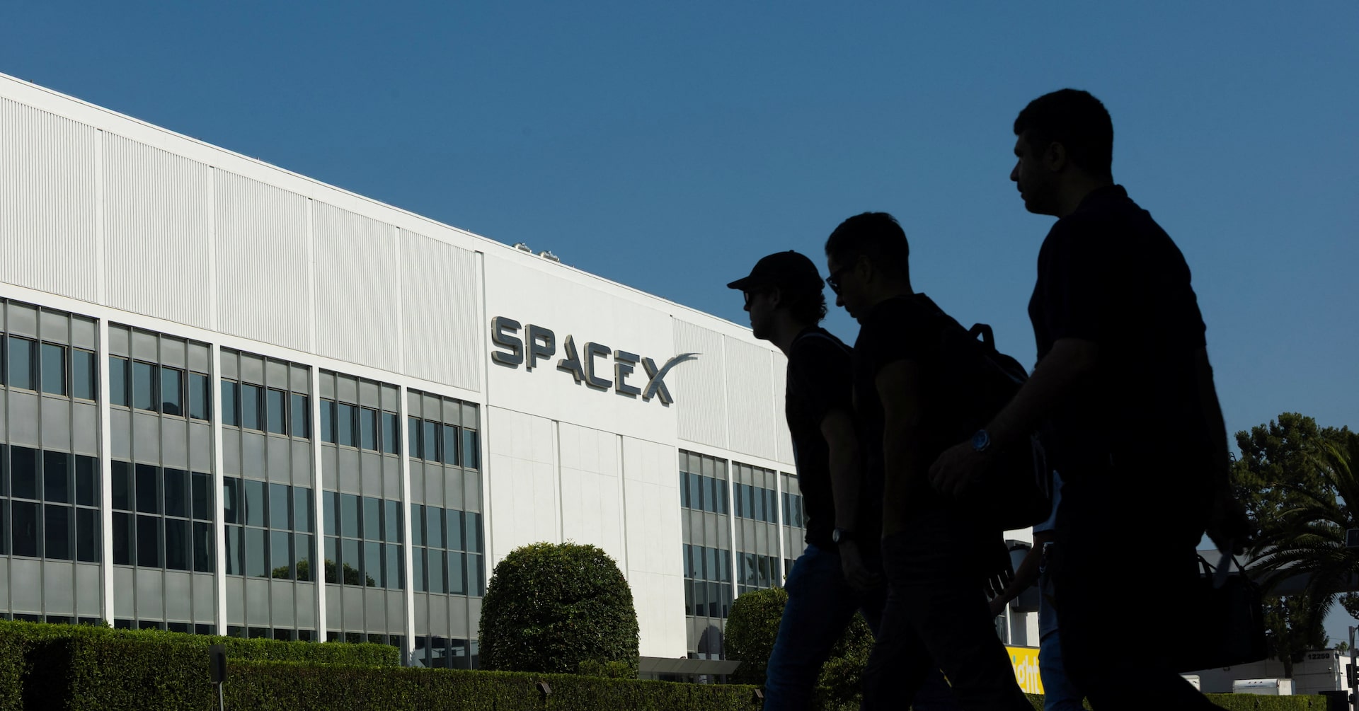 SpaceX employees cross the road as they go to work at the SpaceX facility in Hawthorne on the day of their company's IPO, in Hawthorne, California, U.S. June 12, 2026.