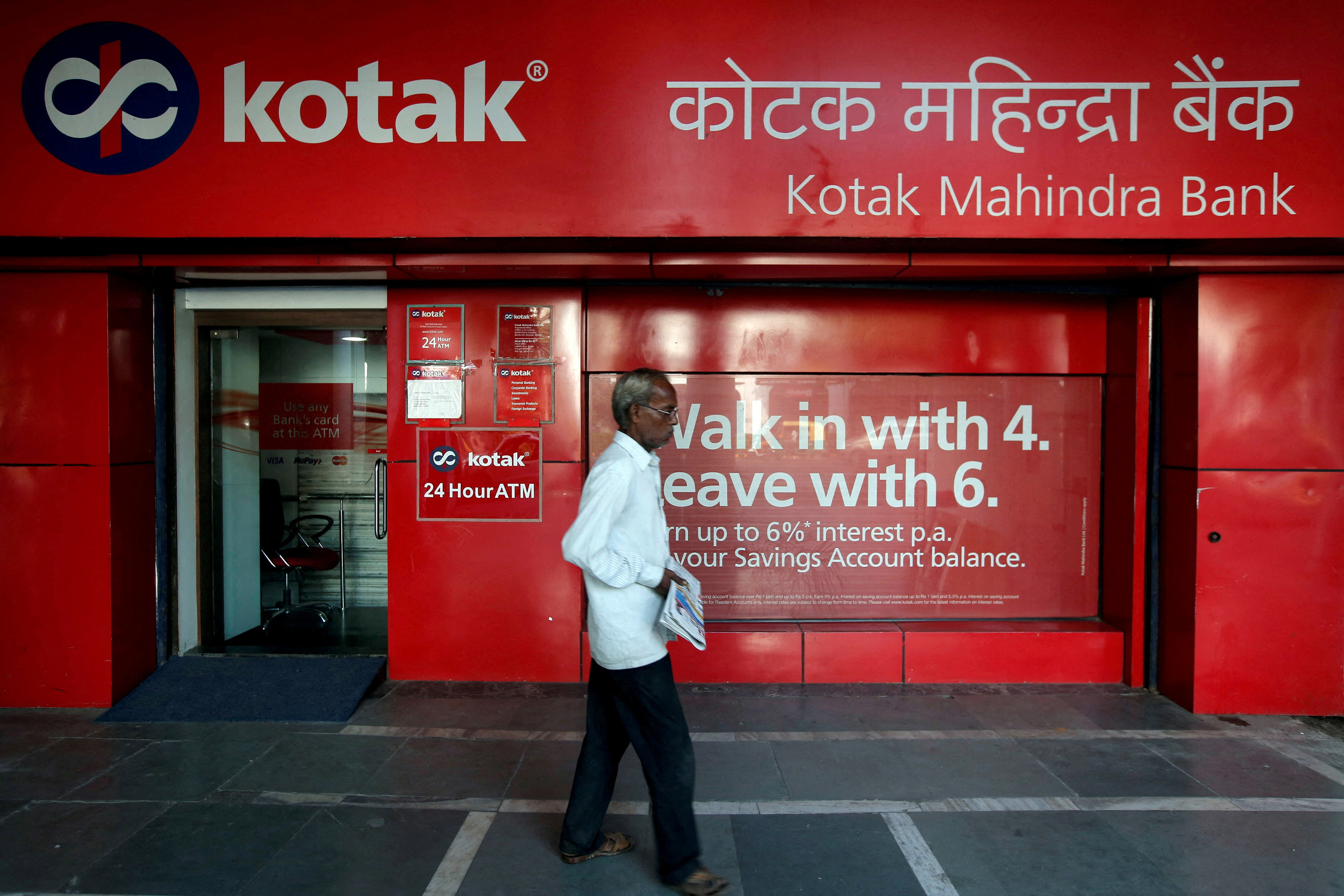 A man walks past a Kotak Mahindra Bank branch in New Delhi, India.