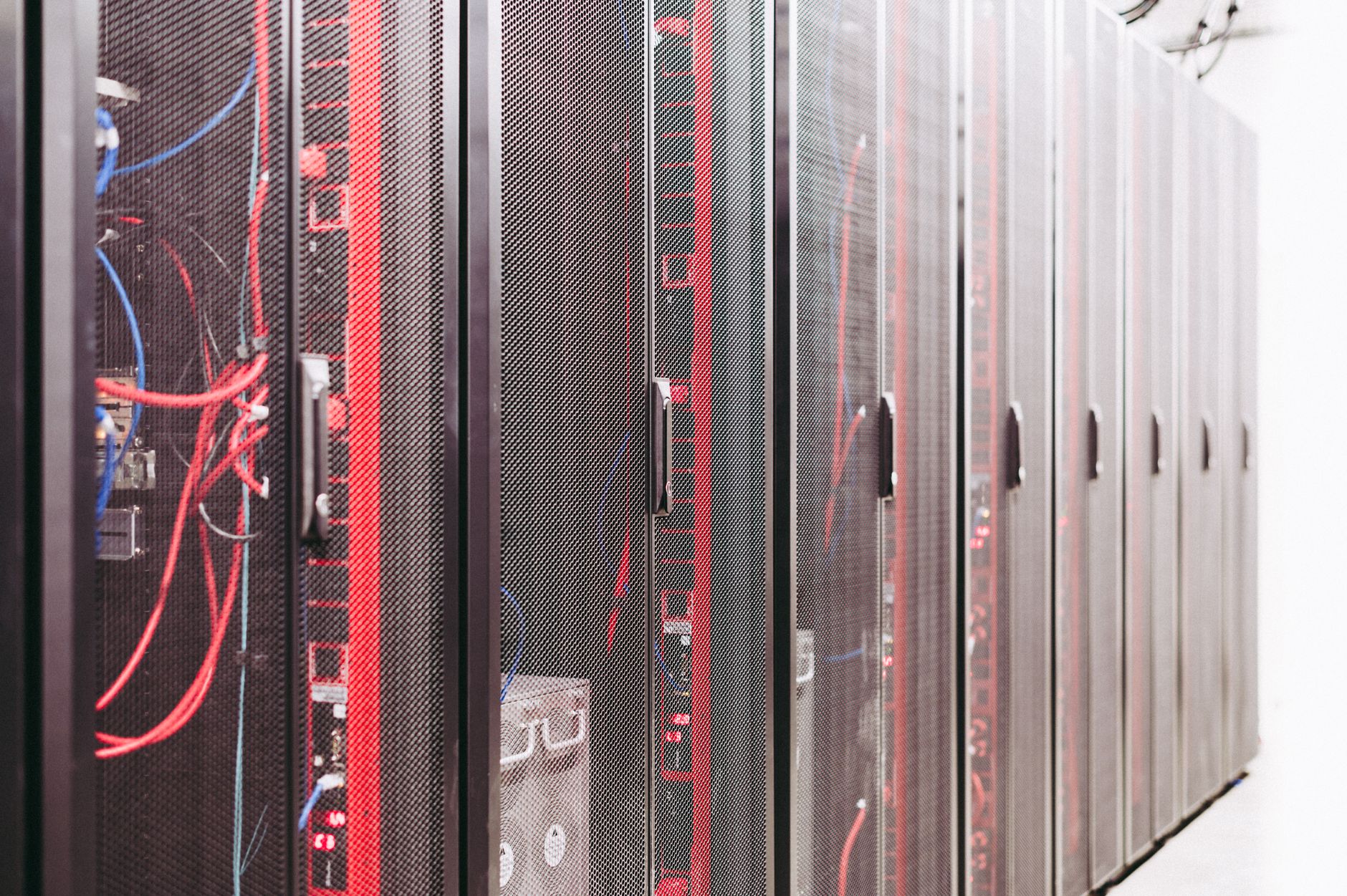 Server racks and network cables in a data center, illustrating infrastructure behind restricted AI model deployment