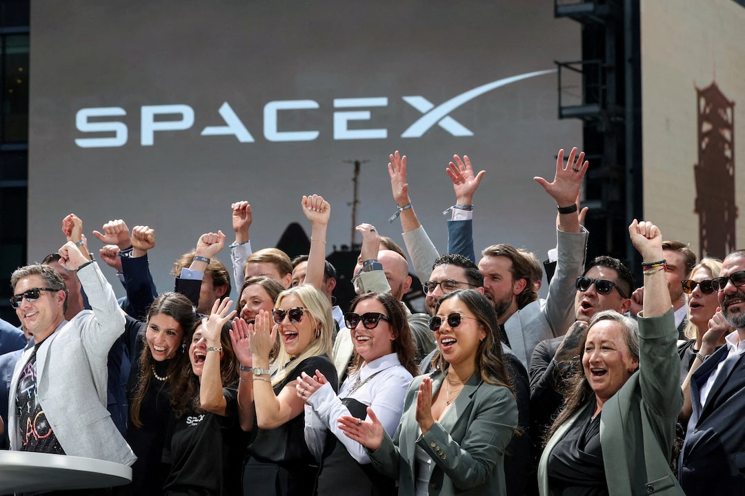 SpaceX leadership members and guests celebrate on a balcony at the Nasdaq MarketSite on the day of SpaceX's initial public offering in New York City, June 12, 2026.