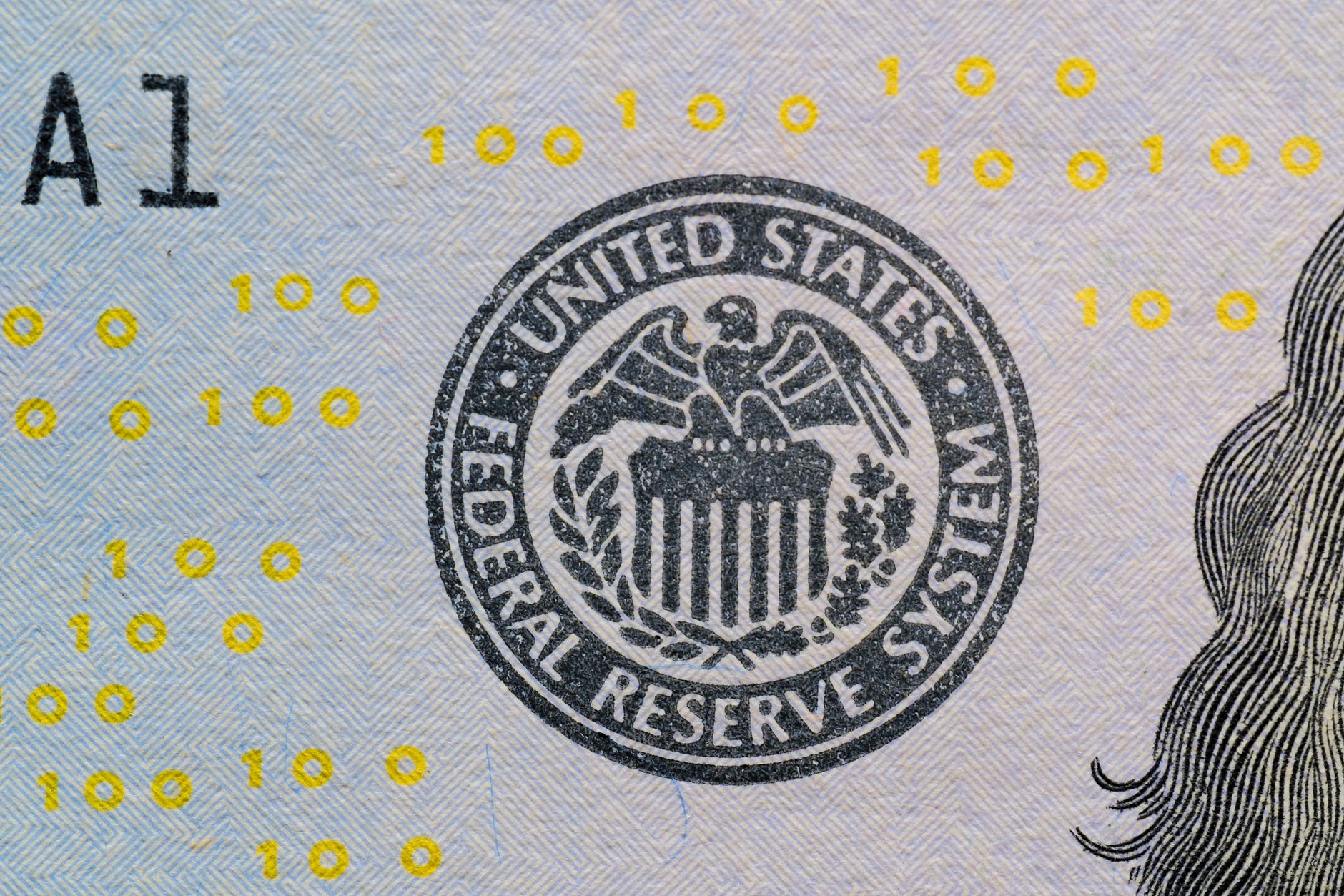 Close-up of a US dollar bill with the Federal Reserve seal and digital numerals