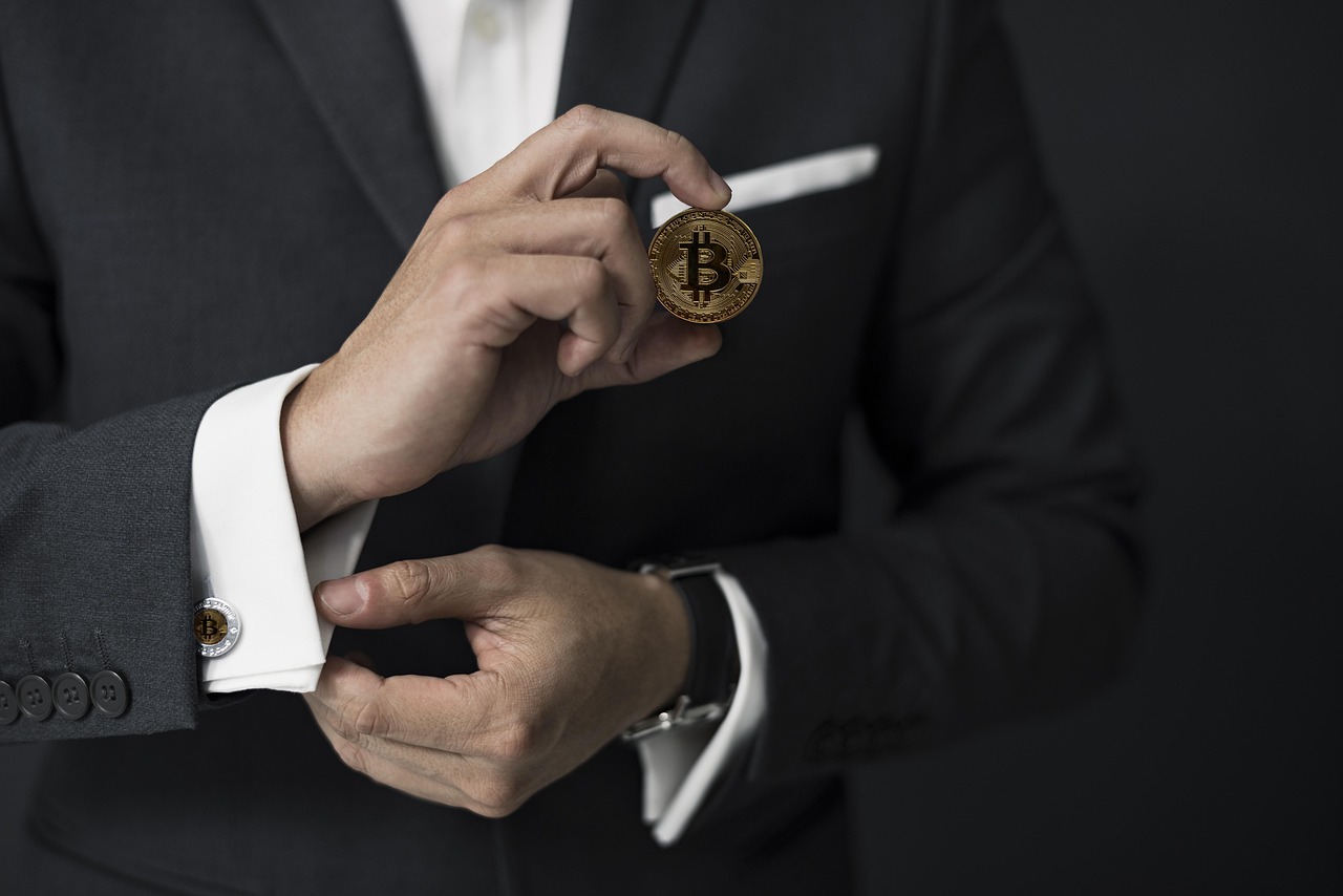 Business executive with a bitcoin token in an office, illustrating corporate crypto treasury management.