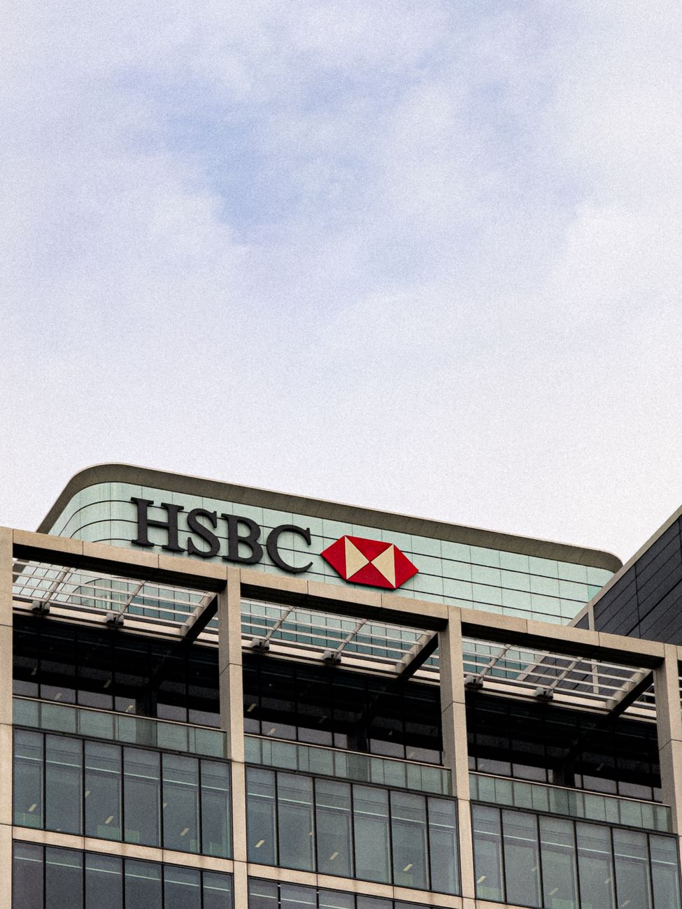 HSBC headquarters with a glass facade under a clear sky