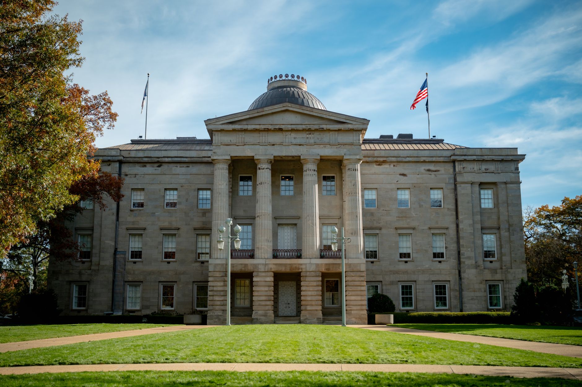 Front view of the historic North Carolina State Capitol in Raleigh under a blue sky