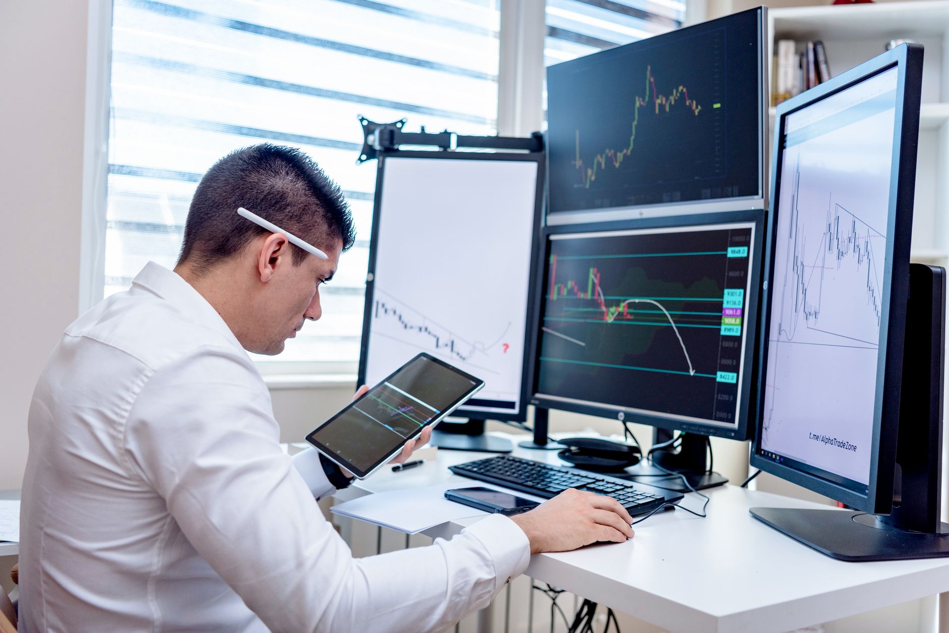 Analyst at a multi-screen trading desk, illustrating the public-market scrutiny that awaits an IPO.
