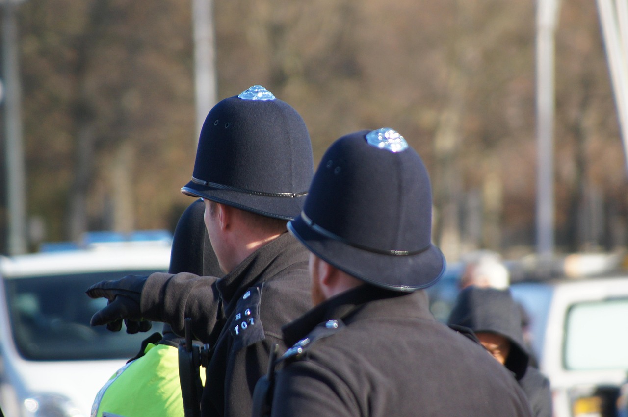 Police officers stand behind barriers on a London street.