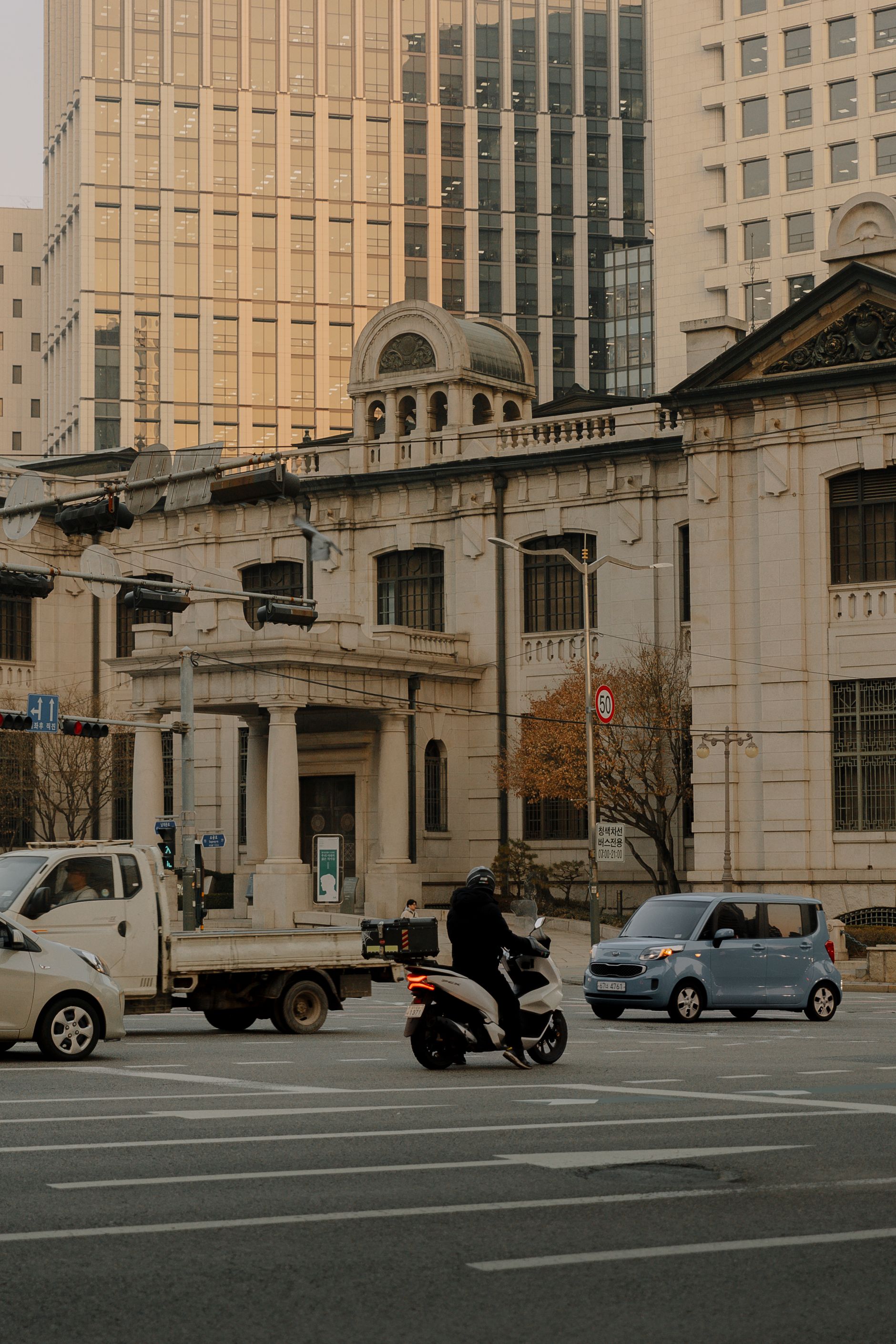 Historic Bank of Korea building in Seoul with vehicles on a busy city street.