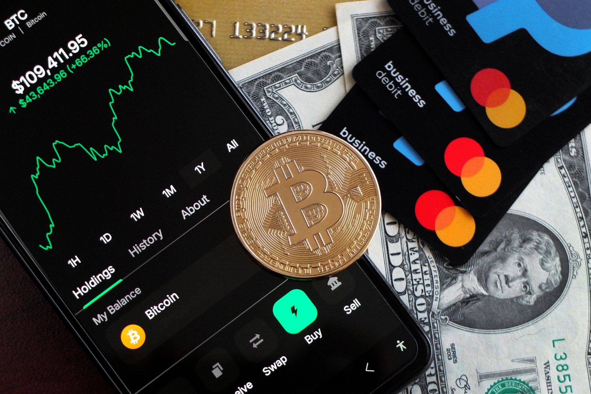 Bitcoin, cards and cash illustrating digital tokens intersecting with payment rails and traditional money.